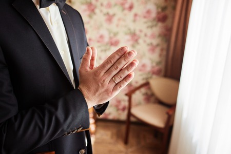 Hands of wedding groom getting ready in suitの写真素材
