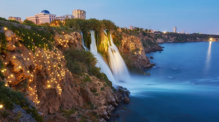 Night view of water cascading from platform into Mediterranean sea in Antalya. Illuninated Lower Duden Waterfall in popular seaside resort city Antalya, Turkey.の写真素材