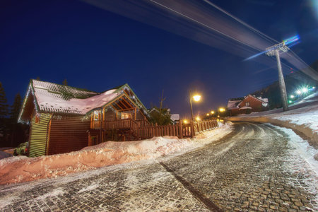 Ski resort in the style of an alpine village, cozy houses for rest in the winter at night