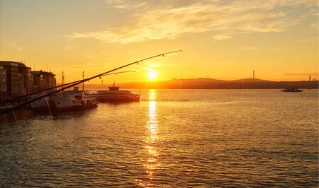 Silhouettes of fishermen fishing on Galata Bridge to relax and enjoy their hobby in Istanbul, Turkeyの写真素材