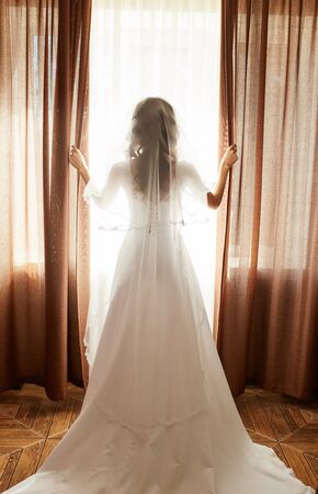 Portrait of the beautiful bride against a window indoorsの写真素材