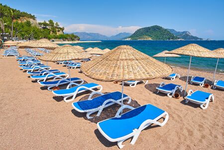 sandy beach without people and with sun loungers, umbrellas, palm trees, Marmaris, Turkey,の写真素材