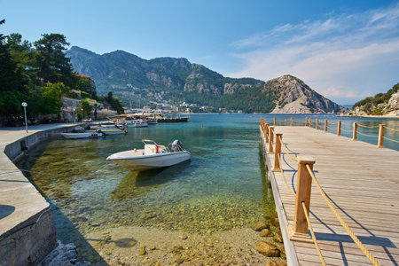 small boats moored in Aegean sea lagoon with mountainous islands around, beach at background and...