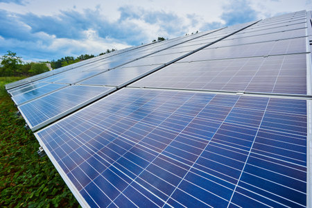 A close-up on a large solar energy system, ground mounted solar panel against blue sky.