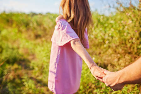 Shot of a young couple holding hands and running through the park. Blurry movement, soft focusの写真素材