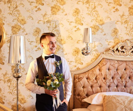 Groom with wedding bouquet. Morning of the groom. Groom morning preparation.
