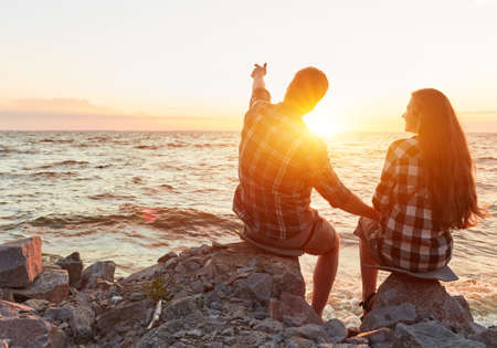 Young couple silhouette on a sea beach on sunset backgroundの写真素材