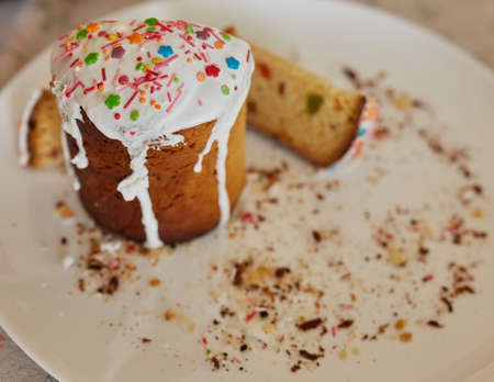 Homemade Easter cake cut into slices on a white plate. Half eaten, a lot of crumbs on the plate.の写真素材
