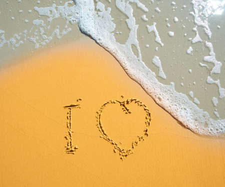 Heart drawn in the sand of sea beachの写真素材