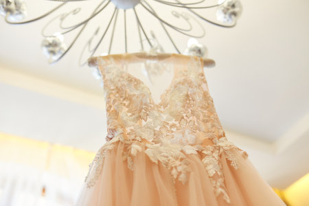 Luxury wedding dress hanging on the chandelier in a hotel room. bridal gown. Bridesmaids. Weddingの写真素材
