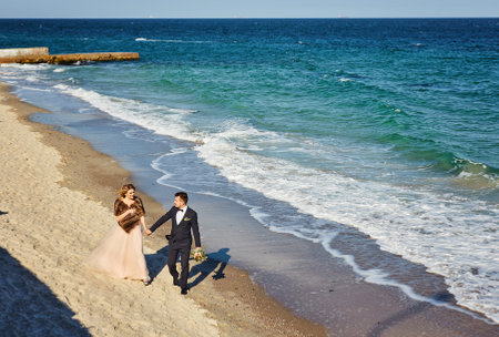 beautiful wedding couple on the beach. the bride and groom celebrate their wedding on the beachの写真素材