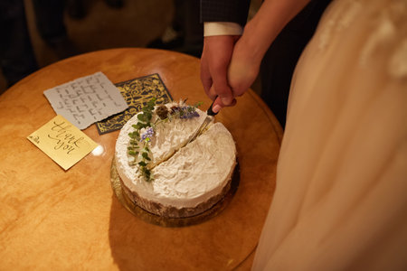 happy bride and groom cut a wedding cakeの写真素材