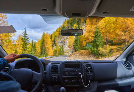A view on the Alps through the windscreen of the car while driving on the curvy road.の写真素材
