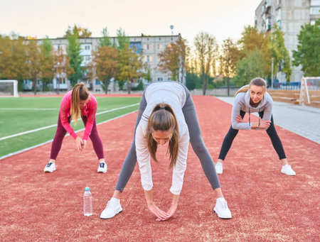 Positive women doing sport exercises..The group of three beautiful young women doing sport in sunny...