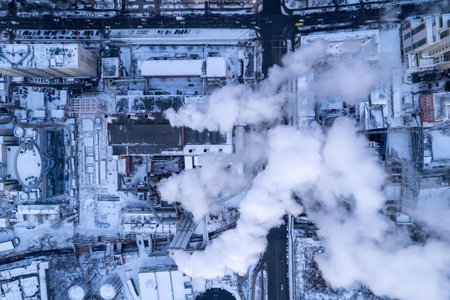Smoke comes out of the heat boiler pipe. Central heating system of apartment buildings. winter sunsetのeditorial素材