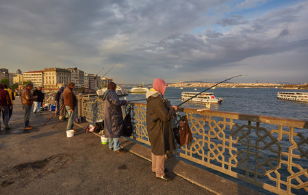 ISTANBUL, ISTANBUL - APRIL 21, 2017: Fishermen on Galata Bridge of Istanbul. Galata Bridge is a bridge that crosses the Golden Horn in Istanbul.のeditorial素材