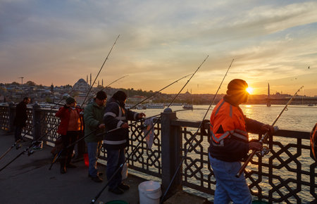 ISTANBUL, ISTANBUL - APRIL 21, 2017: Fishermen on Galata Bridge of Istanbul. Galata Bridge is a bridge that crosses the Golden Horn in Istanbul.のeditorial素材