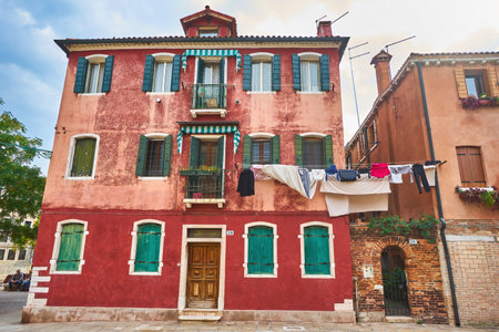 Typical corner city with ancient colorful buildings Drying clothes on a clothes-line in outdoor at sunny summer day. Venice, Italyの写真素材