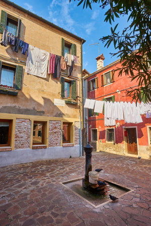 Laundry put to dry on a small traditional and very colorful place on the island of Burano, Italy.の写真素材