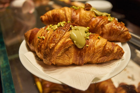 Assortment of freshly baked croissants for sale on counter of shop, market, cafe or bakery. Dessert, pastry, breakfast, sweet food and traditional french cuisine conceptの写真素材