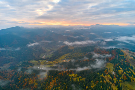 Flight over fog in Ukrainian Carpathians in summer. mountains on the horizon. A thick layer of fog covers the mountains with a continuous carpet. Aerial drone view.の写真素材