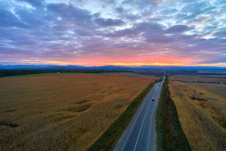 Aerial view of mountain road at sunset in autumn. Top view from drone of road in hills. Beautiful...