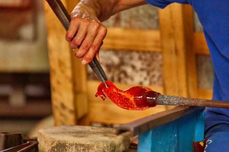 glass master while working in Murano furnace glass factory Venice Italy close up detailの写真素材