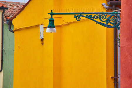 Burano island, traditional colorful walls of the common old houses and a street lantern, architectural background.の写真素材