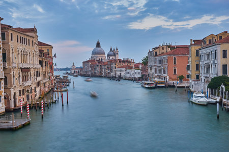 Old canal with bridge, gondola, houses, flowers in cloudy weather.Venice Italyの写真素材