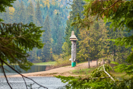 Immerse yourself in the breathtaking beauty of the Carpathian Mountains during autumn. The captivating Synevir Lake reflects the vibrant colors of the surrounding foliage. Lose yourself in the tranquility of this serene landscape, where nature's palette comes alive with hues of gold, orange, and redの写真素材