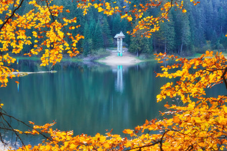 Lake in mystery fog with autumn forest. Ghostly mountain lake. Ukrainian lake Synevirの写真素材