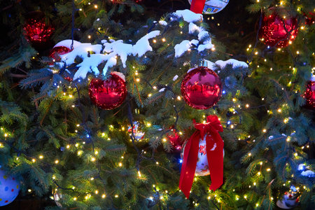 Christmas tree with red balloons on city street at nightの写真素材