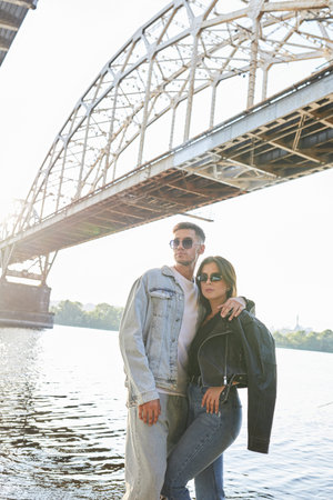 A fashionable and youthful couple exudes style and love while striking poses on the city streets.の写真素材