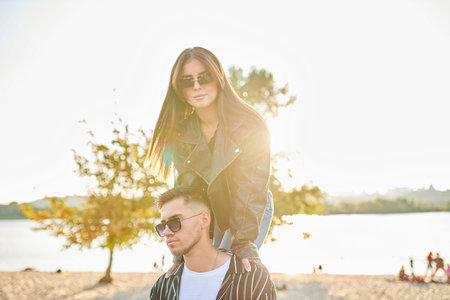 Stylish and young man and woman posing on the street, a couple deeply in love.