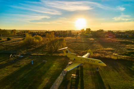 Yellow passenger plane stands in the field. Converted into a tourist site. Top view with a droneの写真素材