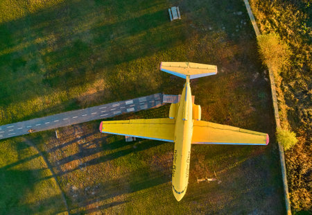 Yellow passenger plane stands in the field. Converted into a tourist site. Top view with a droneの写真素材