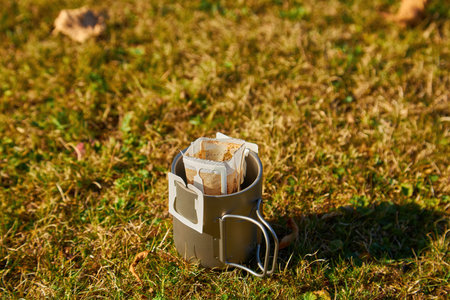 A cup of portable drip coffee is being prepared in the autumn mountains. Against the backdrop of wild natureの写真素材