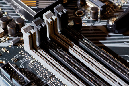 A detailed view of RAM slots on a motherboard, showing the connection points and layout for installing memory modules. Perfect for tech-related content, tutorials, or backgrounds in electronics and computing.の写真素材