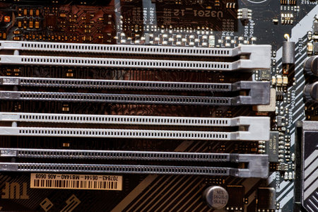 A detailed view of RAM slots on a motherboard, showing the connection points and layout for installing memory modules. Perfect for tech-related content, tutorials, or backgrounds in electronics and computing.の写真素材