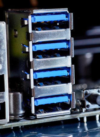 A detailed macro shot of multiple USB 3.0 ports on a computer motherboard, highlighting the blue connectors and metal casing. Suitable for illustrating hardware or technology-related concepts.の写真素材