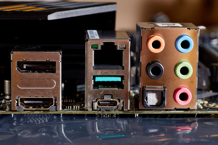 A detailed close-up of a computer motherboard, showing various ports including Ethernet, USB, HDMI, and audio connections. Ideal for illustrating technology or electronics-related themes.の写真素材