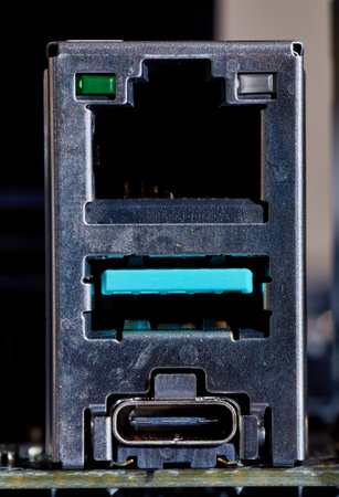 A close-up view of an Ethernet port, a teal-colored USB port, and a USB Type-C port on a computer motherboard, showing their design and structure. Ideal for technology and hardware visuals.の写真素材