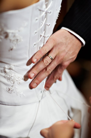 Hand the man with a ring on a finger at a dress of the brideの写真素材