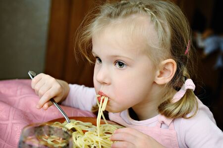 The little girl eats tasty macaroniの写真素材