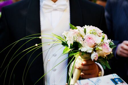 Groom with the bride's bouquetの写真素材