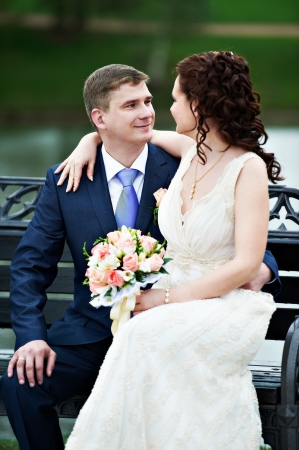 Bride and groom embrace on a benchの写真素材