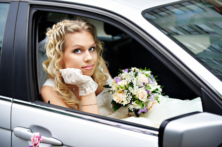 Happy bride in a wedding carの写真素材