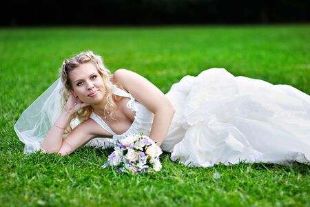 Happy bride on grass in parkの写真素材