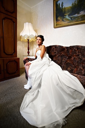Beautiful Bride in long wedding dress in a classical interior at homeの写真素材