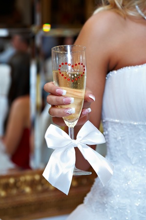 Stylish wedding glass of champagne in hand bride with golden ringの写真素材
